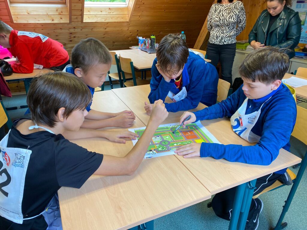 Chlapci u stolu hledají správnou trasu na mapě v disciplíně dopravní labyrint.